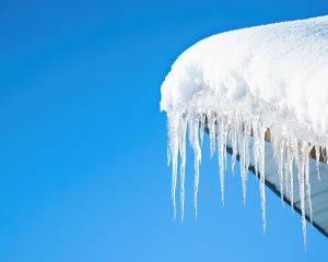 a metal roof with snow and icicles
